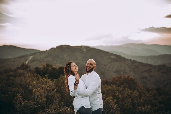 Affectionate couple having fun on hilly valley