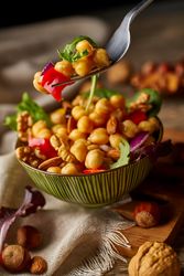 Bright vegetables with chickpeas in bowl and walnuts