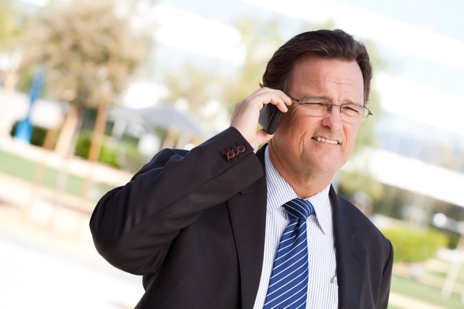 Businessman Smiles as He Talks on His Cell Phone