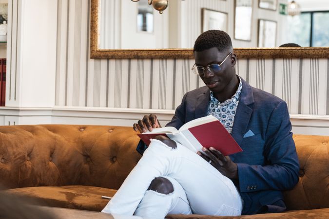 Pensive Black businessman reading book in cafe