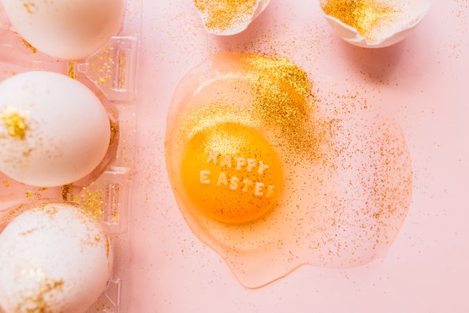 Easter eggs in box and broken egg on table