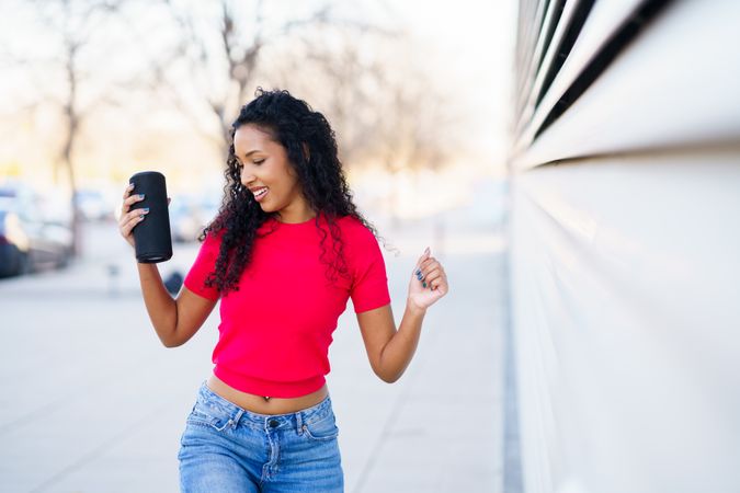 A Young Woman Joyfully Enjoys Music Outdoors in a Trendy Outfit, Reflecting Freedom and Fun