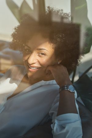 Smiling Hispanic woman resting in armchair