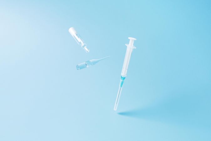 Medical syringes on blue background with copy space