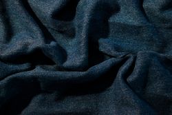 Close up detail crumpled wavy Navy blue jeans fabric background texture.