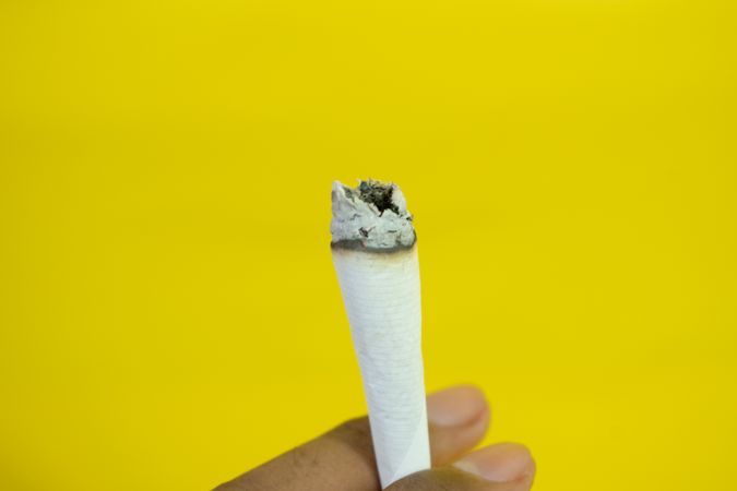 Close up of hand holding cigarette