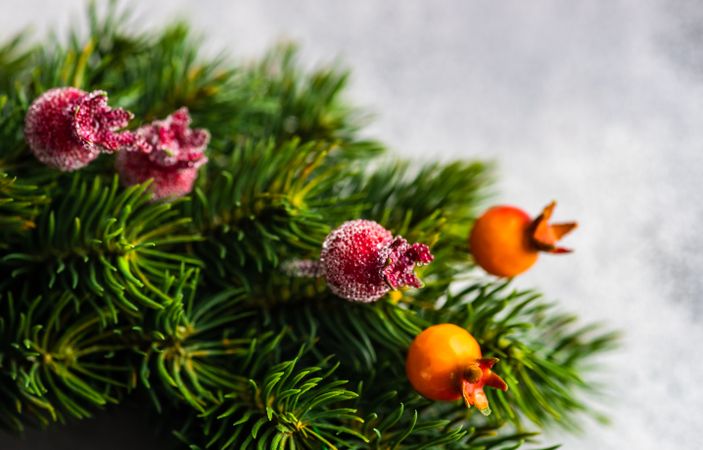 Close up of Christmas wreath with red berry detail on marble counter