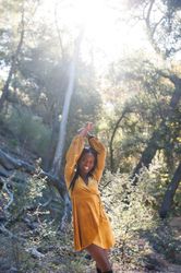 Smiling woman in fashionable velvet dress in the woods