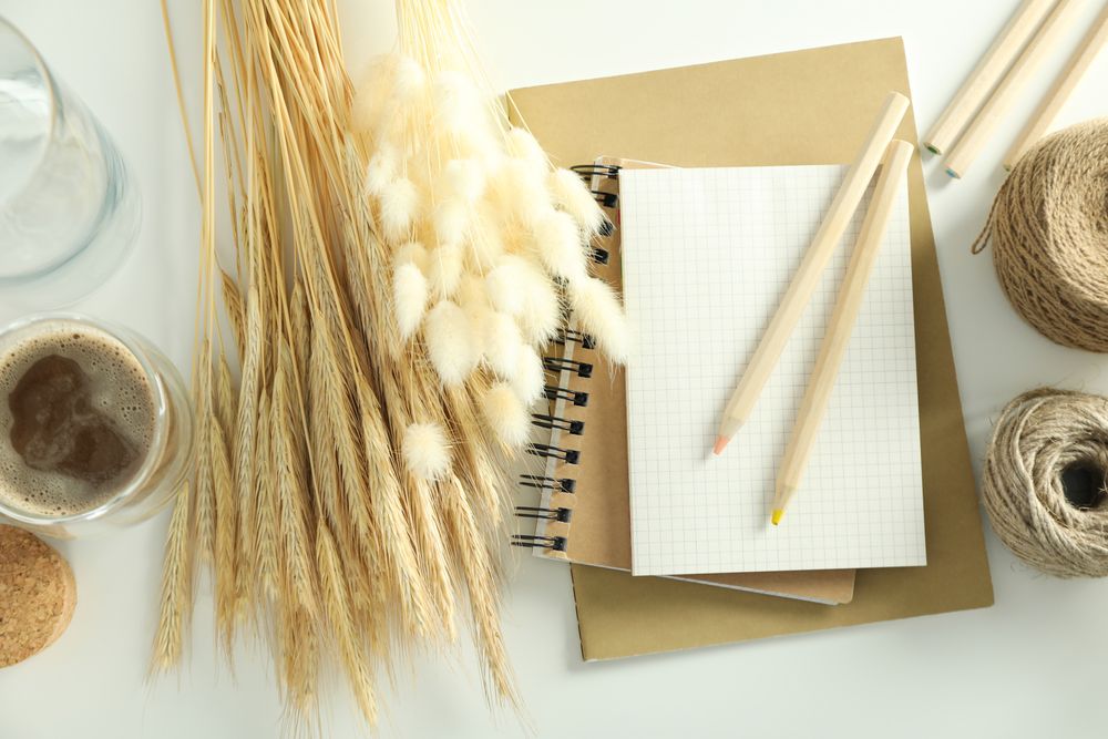 Looking down at table of arts and crafts supplies with note book