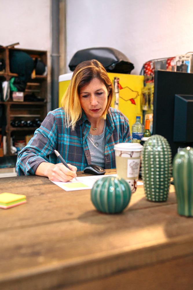 Portrait of blonde young woman checking orders received by ecommerce shop