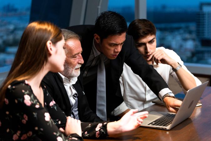 Group of people focused on a laptop in an office