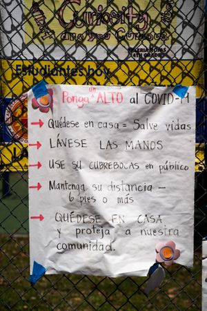 Close up view of handmade sign with coronavirus prevention tips written in Spanish