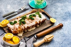 Fresh baked lemon cake dessert with mint garnish on cutting board