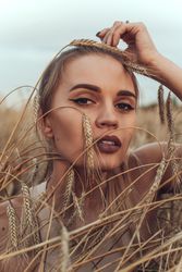 Portrait of young woman in brown wheat field