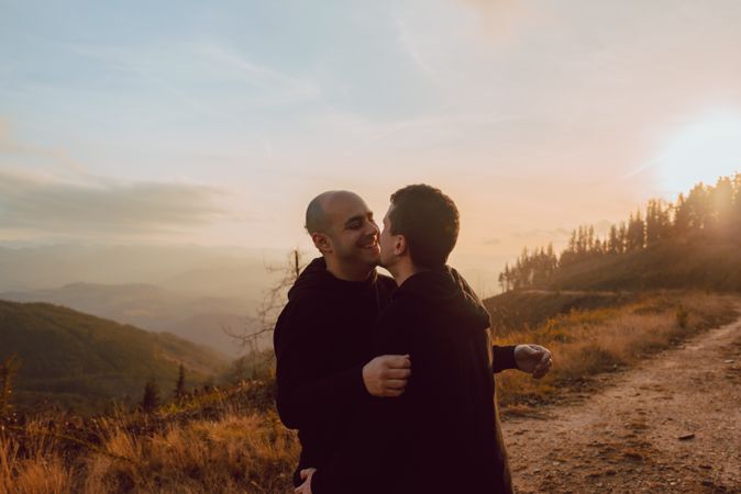 Men hugging and kissing in forest