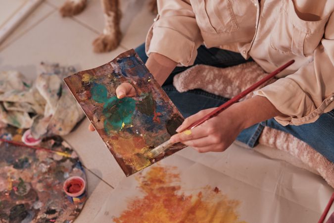 Crop artist painting on paper in art studio