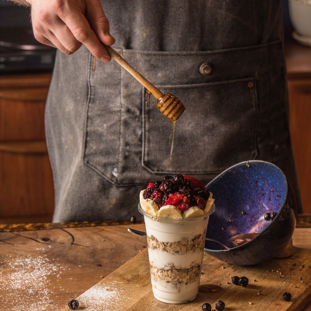 Chef adding honey to granola parfait on top