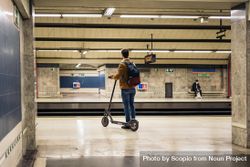 Man riding scooter in subway bDAvr0