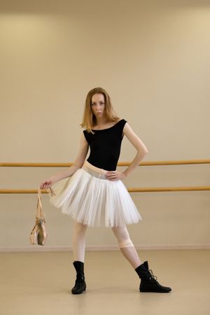 Ballerina posing with pointe shoes in hand