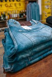 Close up of blue jeans pants stacks over counter on vintage clothes shop