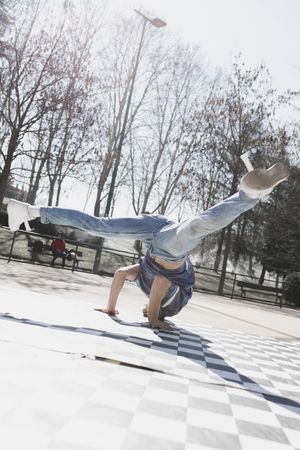 Man dancing break dance in park