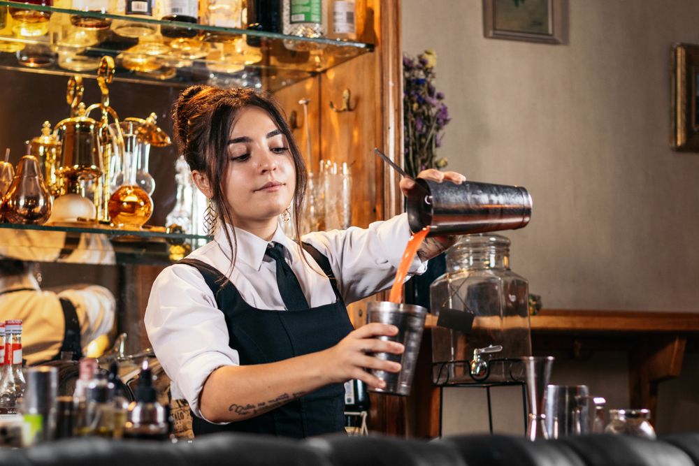 Female bartender preparing a cocktail in a traditional cocktail bar