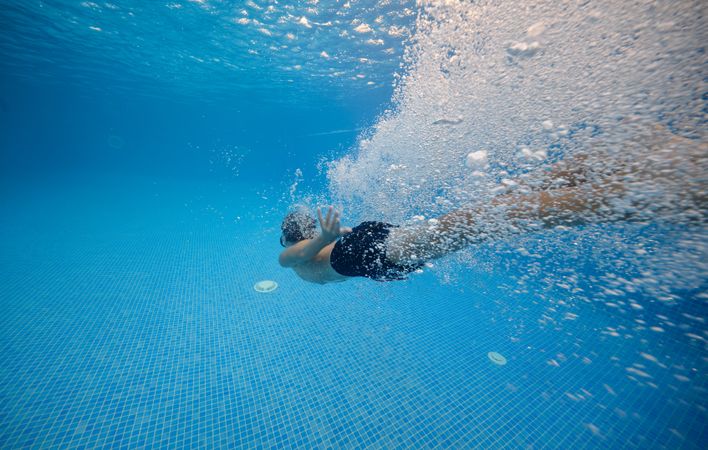 Boy diving in pool with clean water