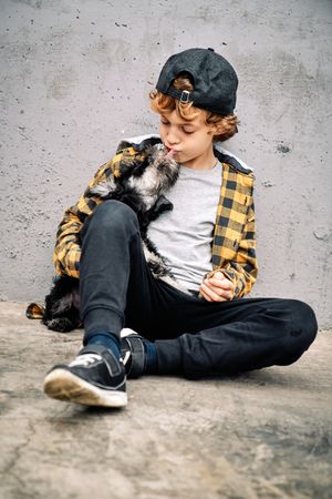Cute child and small dog on street