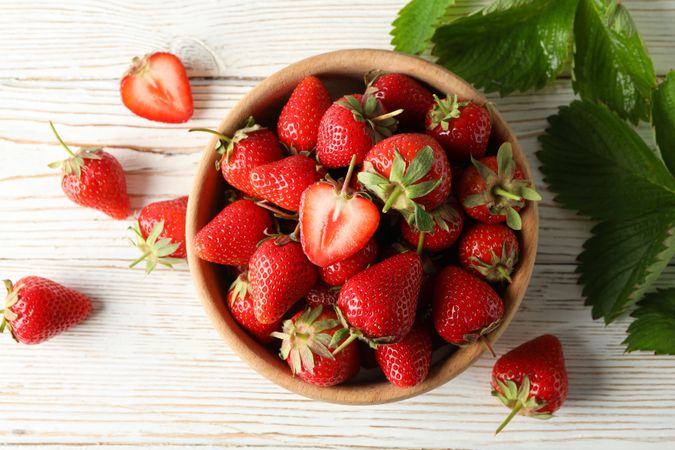 Bowl with tasty strawberry on wooden table. Summer berry