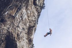 Anonymous climber handing on cliff