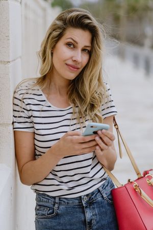 Woman using phone on city street