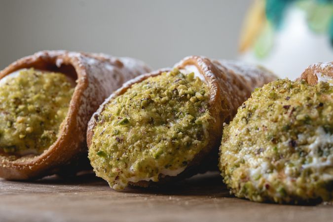 Sicilian cannoli with pistachio topping and traditional jug background