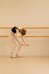 Ballet dancer extending arms in graceful arc.