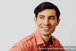 Headshot of smiling Hispanic male looking away in grey studio, copy space 5wBKy0