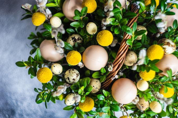 Top view of eggs & flowers in decorative Easter basket