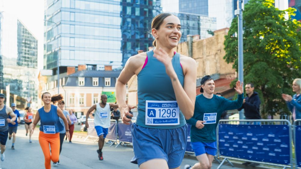 Diverse Group of People Running a Marathon in a City During the Day.