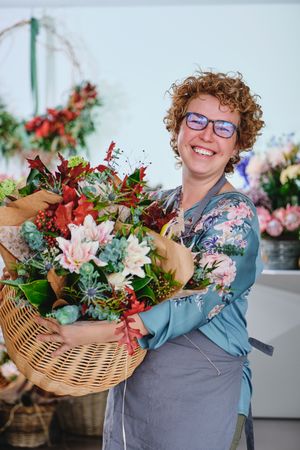Smiling florist with bouquet of flowers in store