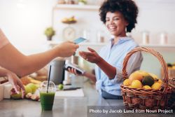 Shot of a female juice bar owner taking payment from customer 5Q3WEb