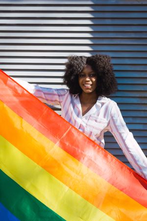 Female posing happily with the LGBT flag