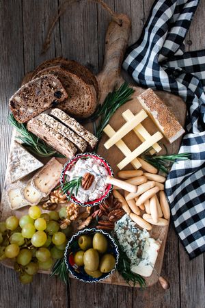 Bred, cheese, olives and grapes on wooden board