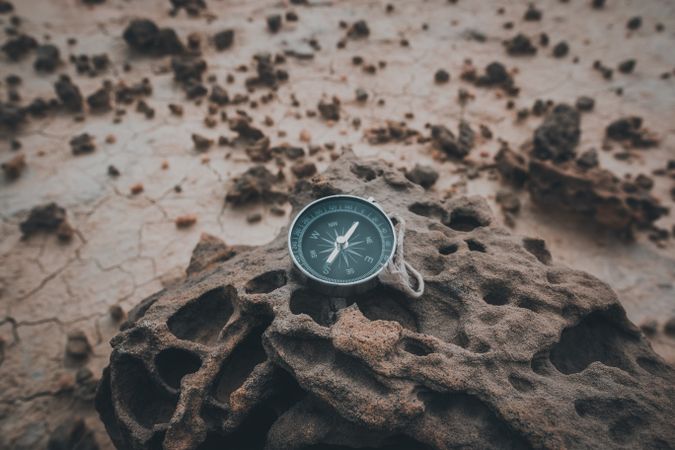 Big compass on dry cracked desert area