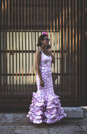 Erratic woman in flamenco dress talking on phone at street