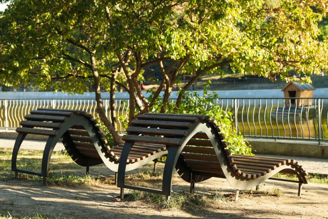 Beautiful city park with lake and sunbeds in sunny morning