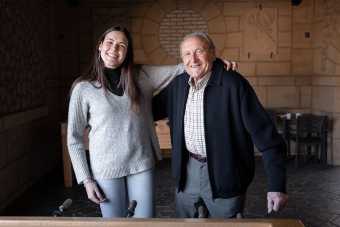 A granddaugther and his grandfather are playing table football game and having fun together