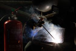 Person welding metal in a dark room 4dgLN5