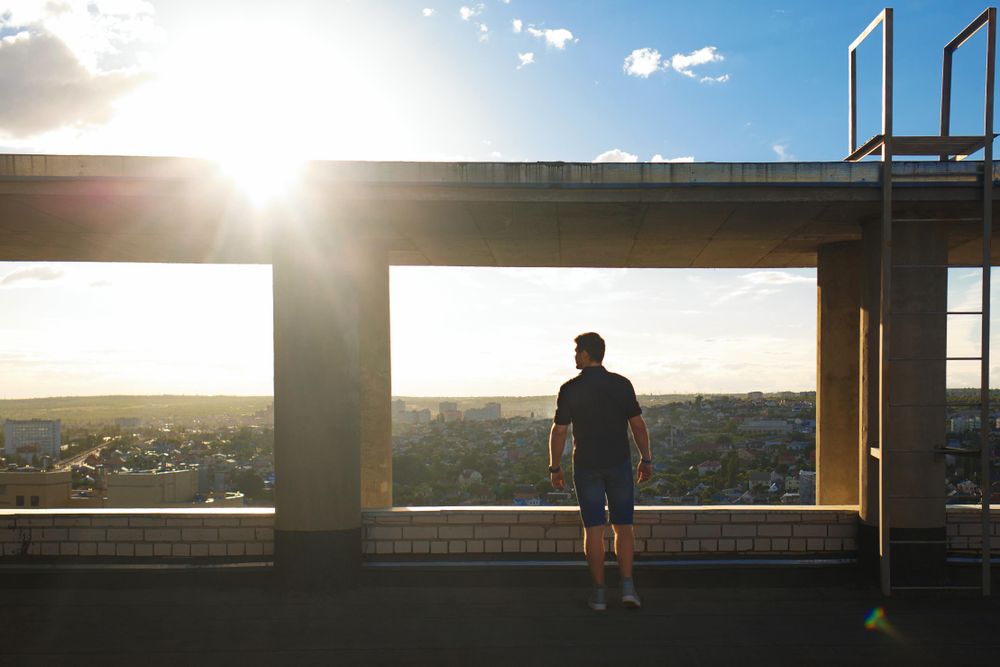 Silhouette of man in frame on top of building