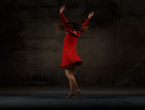 Young woman dancing in darkness