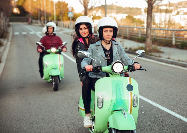 Young people riding motorcycles on city road