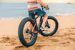 Male sitting on bicycle along the coast