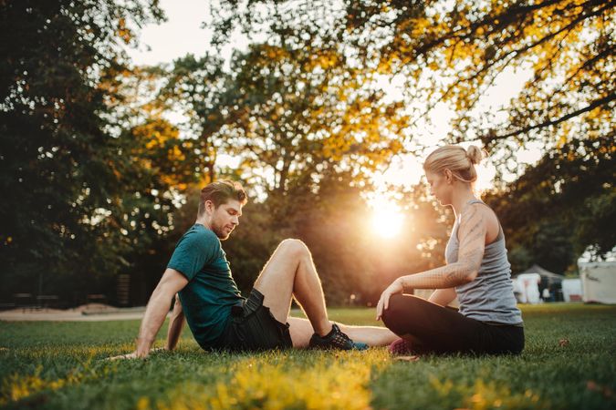 Shot of young couple sitting at park cooling down after workout